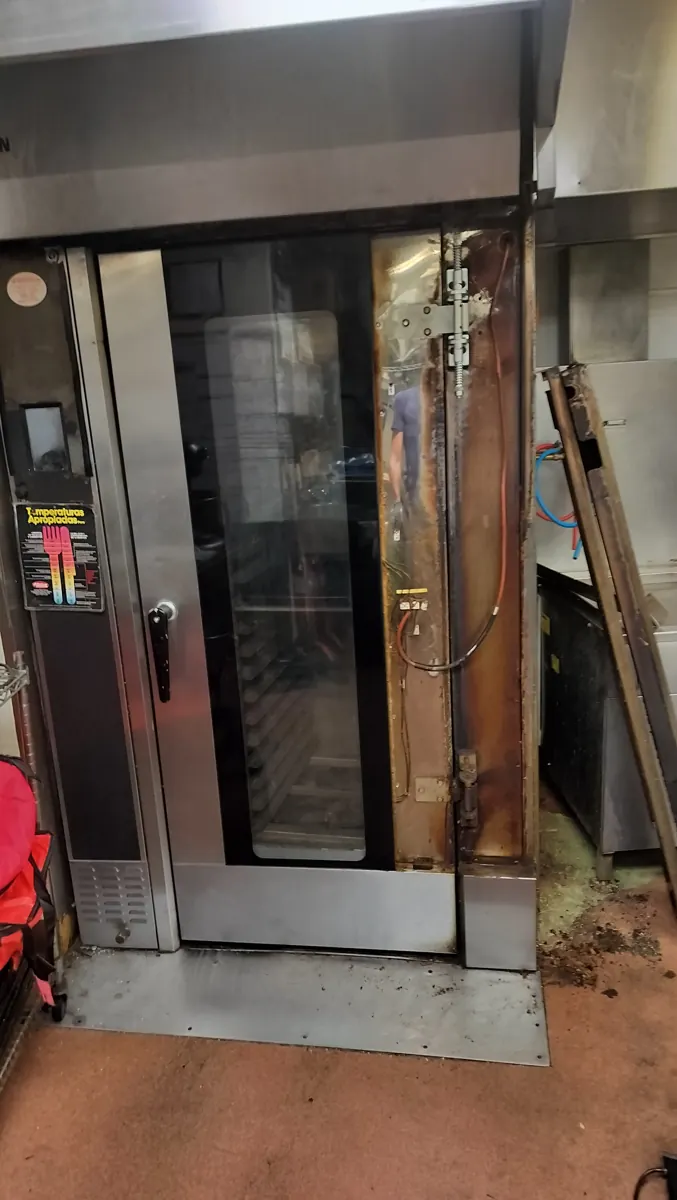 Sveba-Dahlen C152 commercial rack oven with its door-hinge area exposed during hinge service.